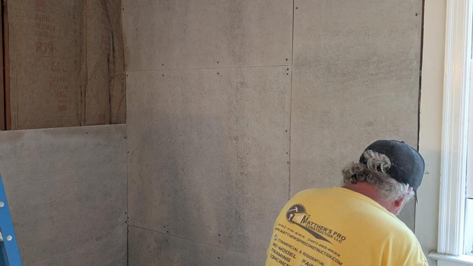 Contractor reviewing construction blueprints inside a home being renovated